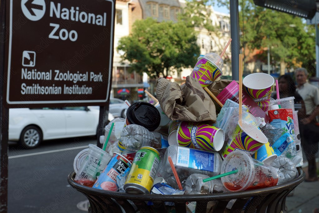 Le panneau du National Zoo, une poubelle débordante de gobelets au premier plan.
