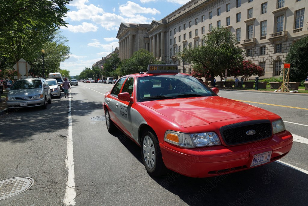 Un taxi rouge de Washington circule le long d'une avenue bordée de bâtiments officiels.