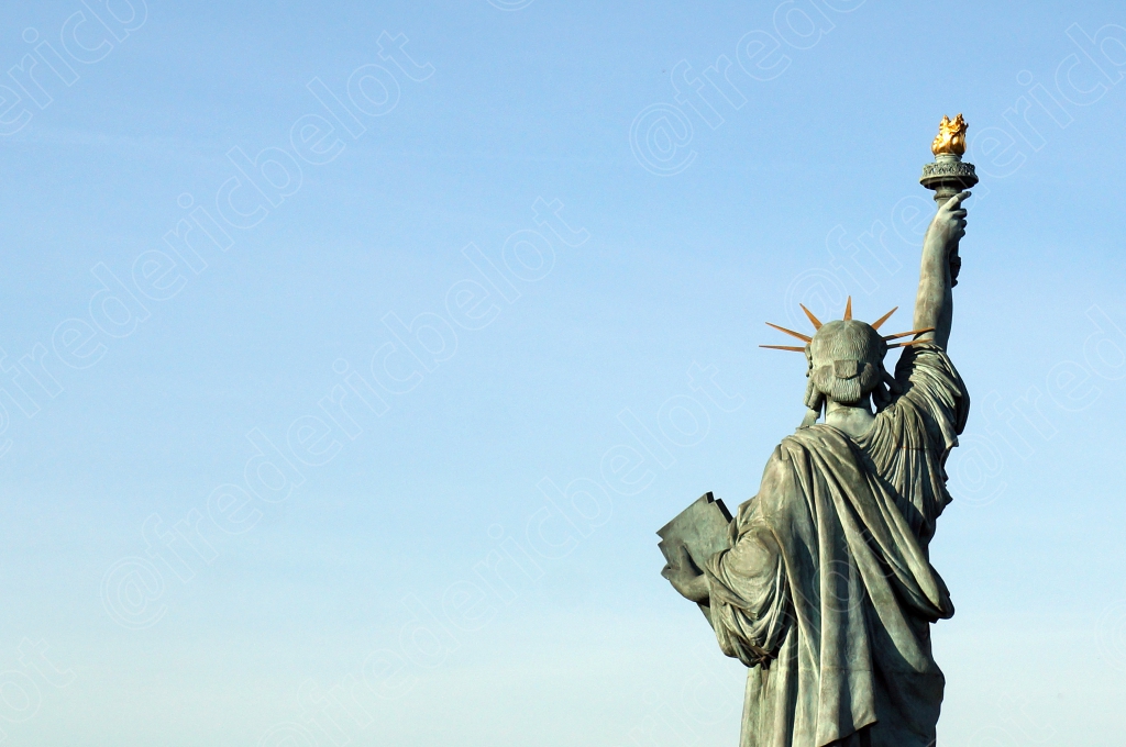 La réplique de la Statue de la Liberté sur l'île aux Cygnes, torche levée vers un ciel bleu dégagé.