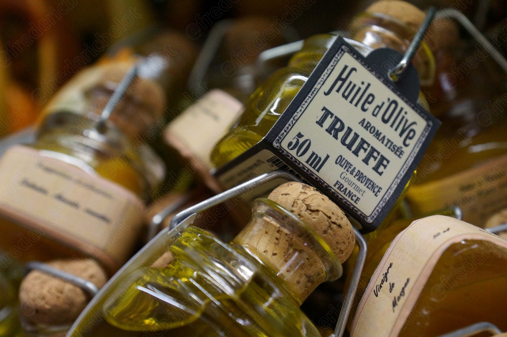 Des bouteilles d'huile d'olive à la truffe alignées sur un étal.