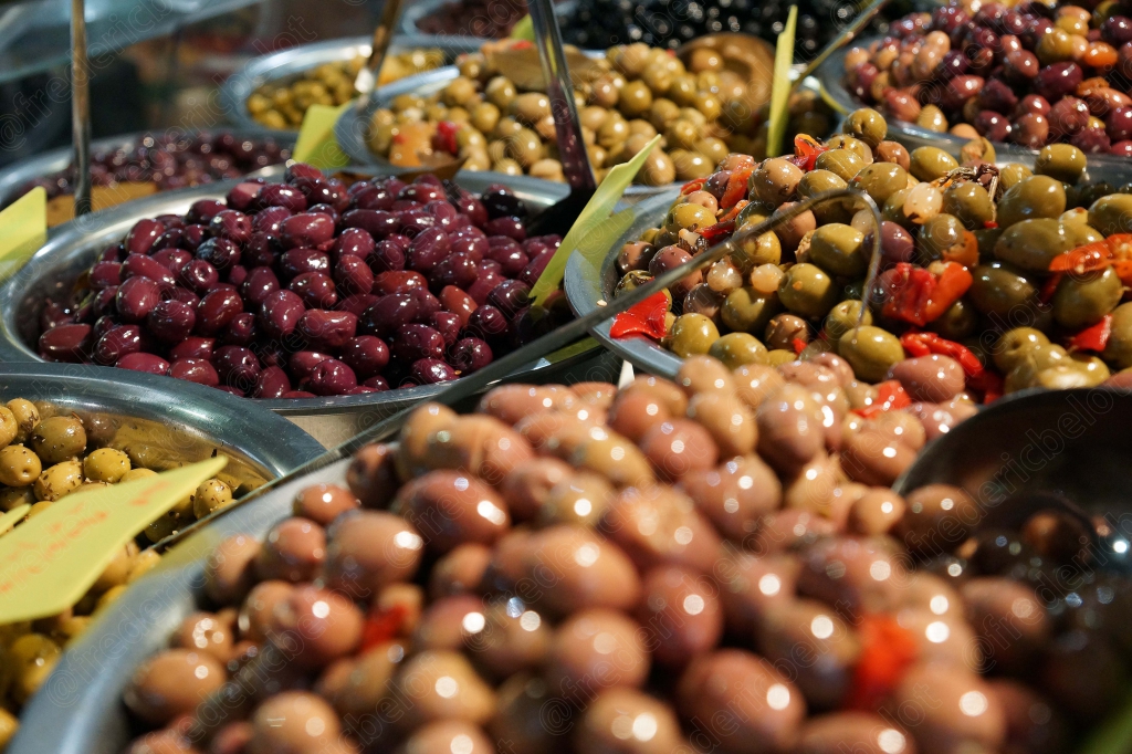 Un étal d'olives variées présentées dans des bacs métalliques.