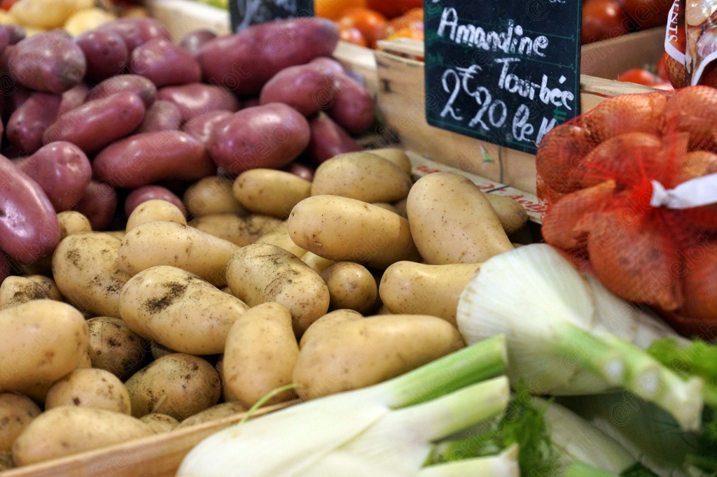 Des pommes de terre nouvelles et du fenouil frais présentés sur un étal.