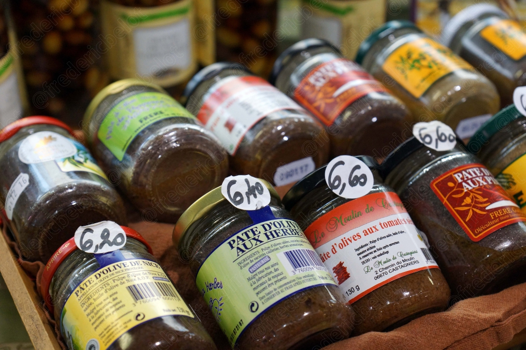 Des pots de tapenade et de confitures artisanales étiquetés avec leur prix.