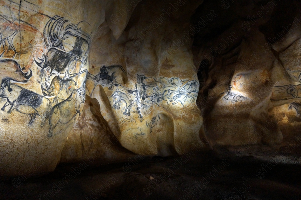 Fresque pariétale représentant une frise d'animaux gravés et peints sur la paroi rocheuse.