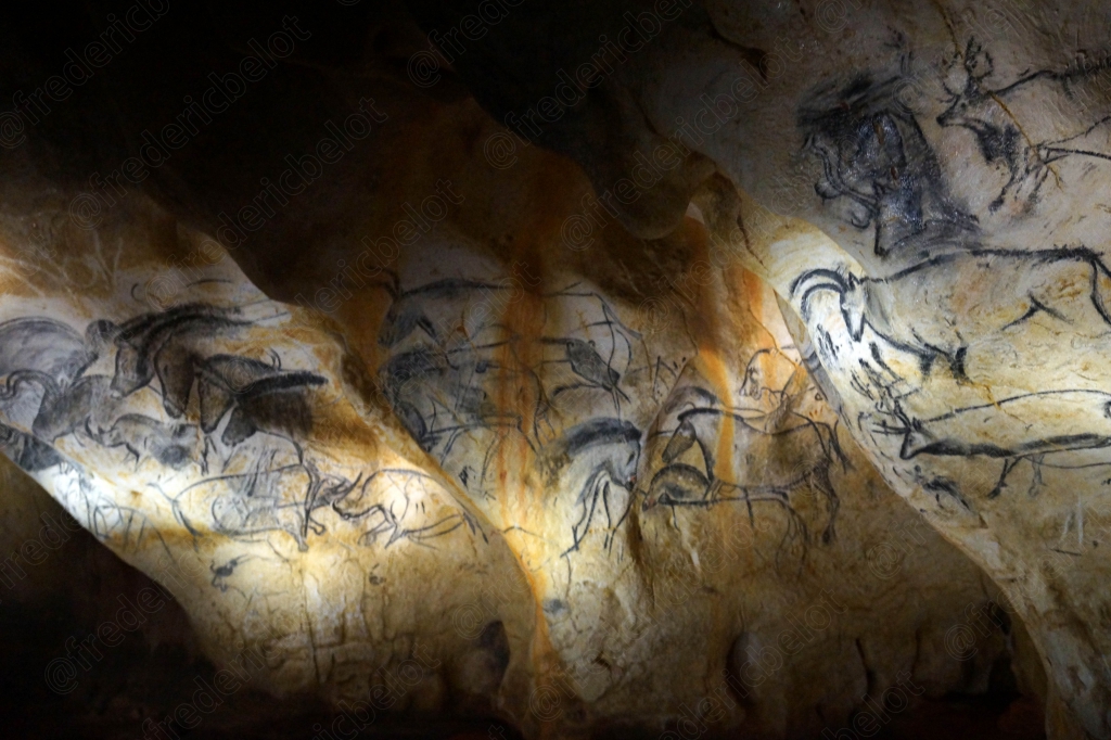 Une paroi de la grotte montre plusieurs silhouettes animales superposées, entre ombre et lumière.