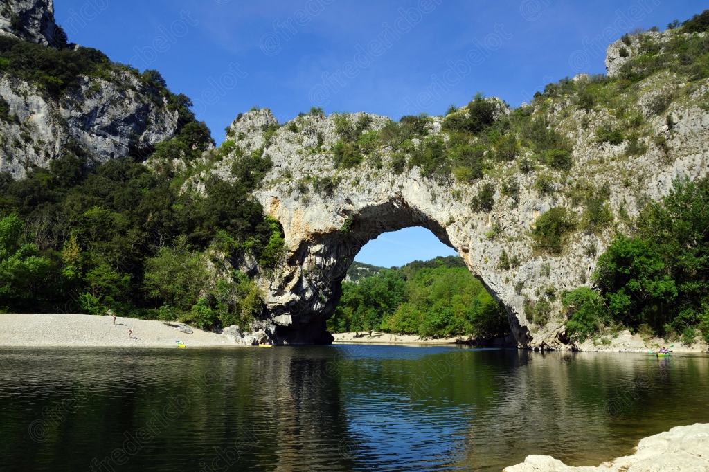 Vue rapprochée du Pont d'Arc et de son reflet dans les eaux calmes de l'Ardèche.