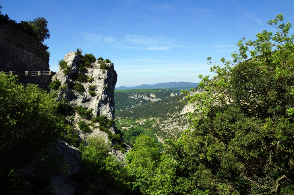 Un piton rocheux surplombe la route en lacets qui longe les gorges.