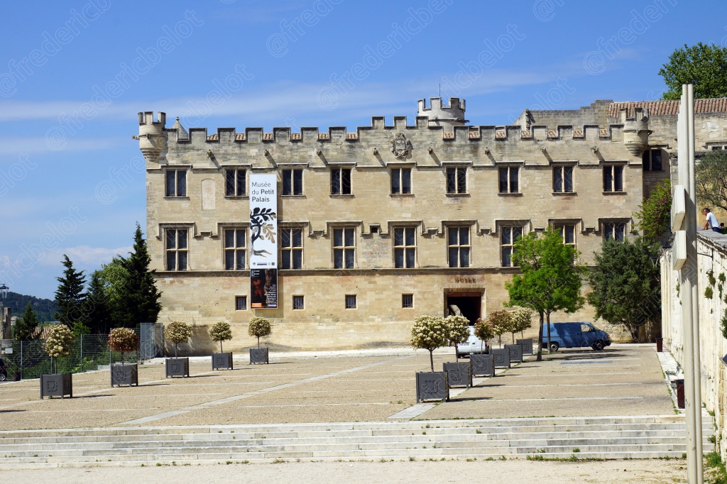 La façade classique et symétrique d'un ancien hôtel particulier, place pavée en premier plan.