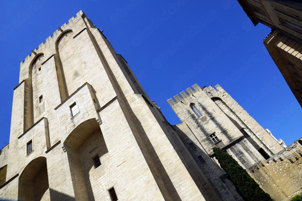 Vue en contre-plongée sur les tours massives du Palais des Papes.