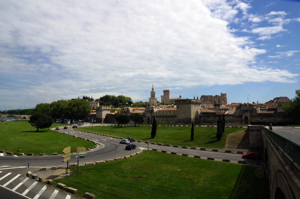 Vue d'ensemble sur les remparts d'Avignon et la silhouette du Palais des Papes au loin.