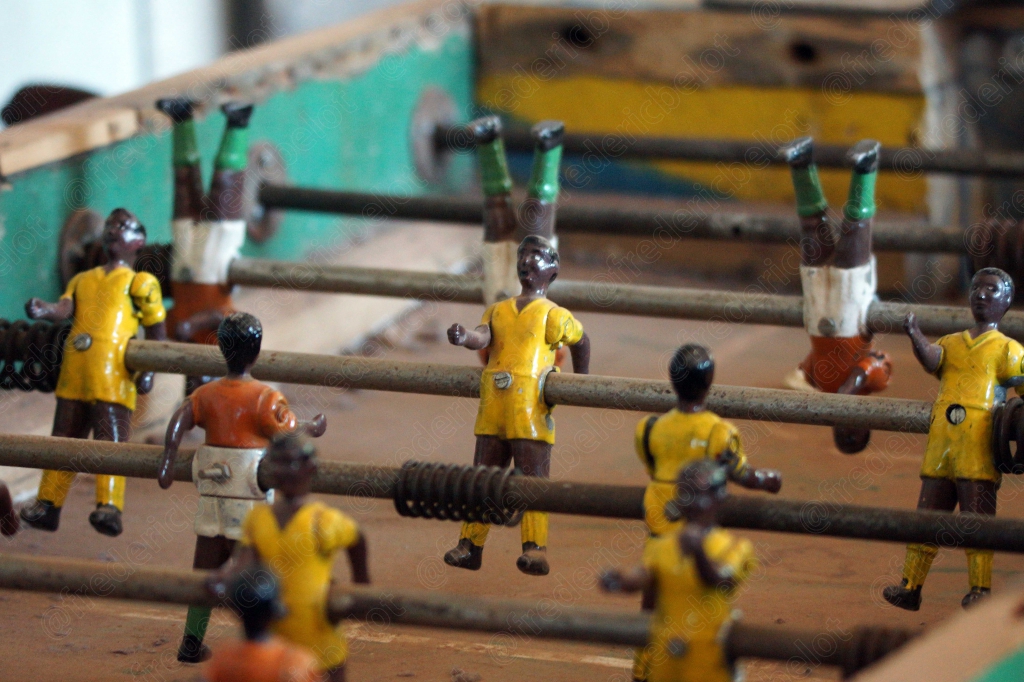 Les figurines colorées d'un baby-foot, vues de dessous en contre-plongée.