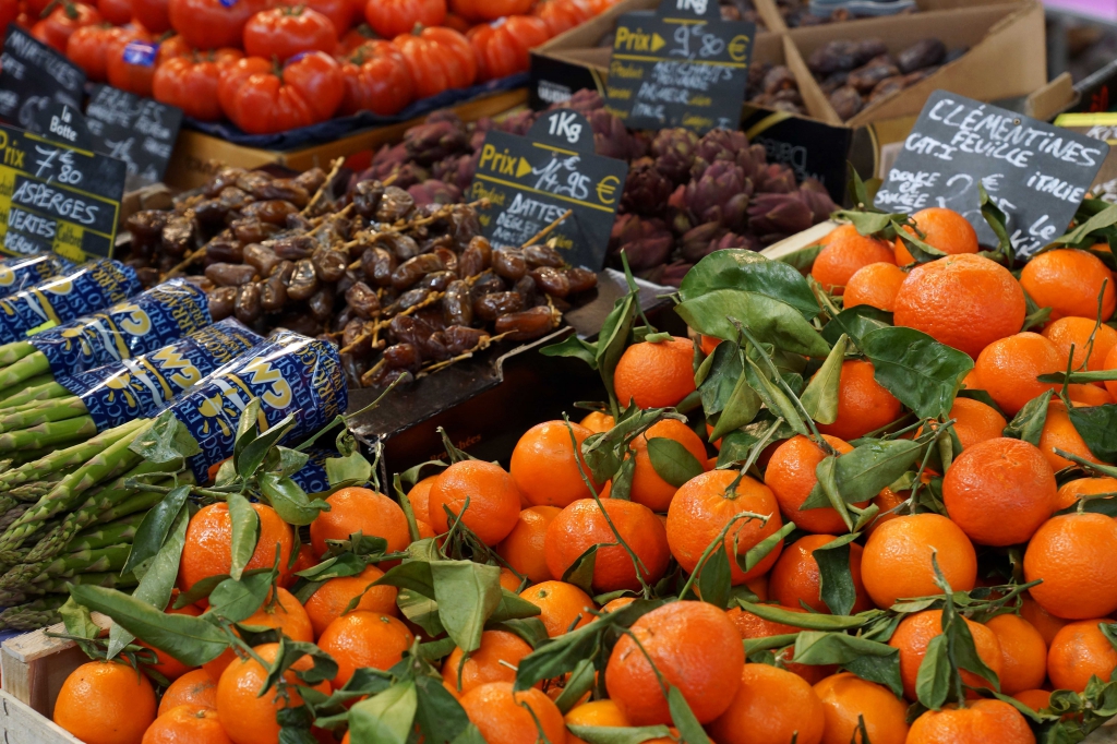 Un étal de clémentines et de fruits secs, étiquettes de prix visibles.