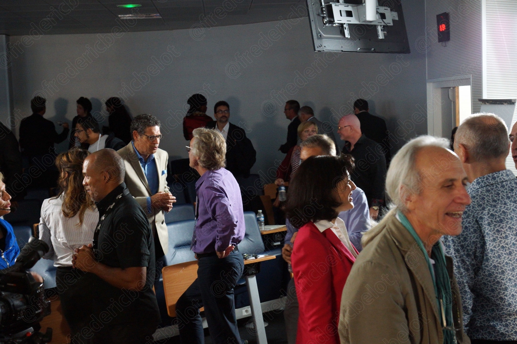Un groupe de participants discute debout dans le hall de la convention.