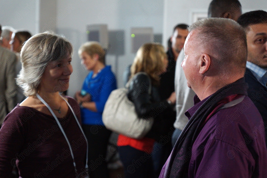 Des participants discutent debout dans le hall pendant une pause.