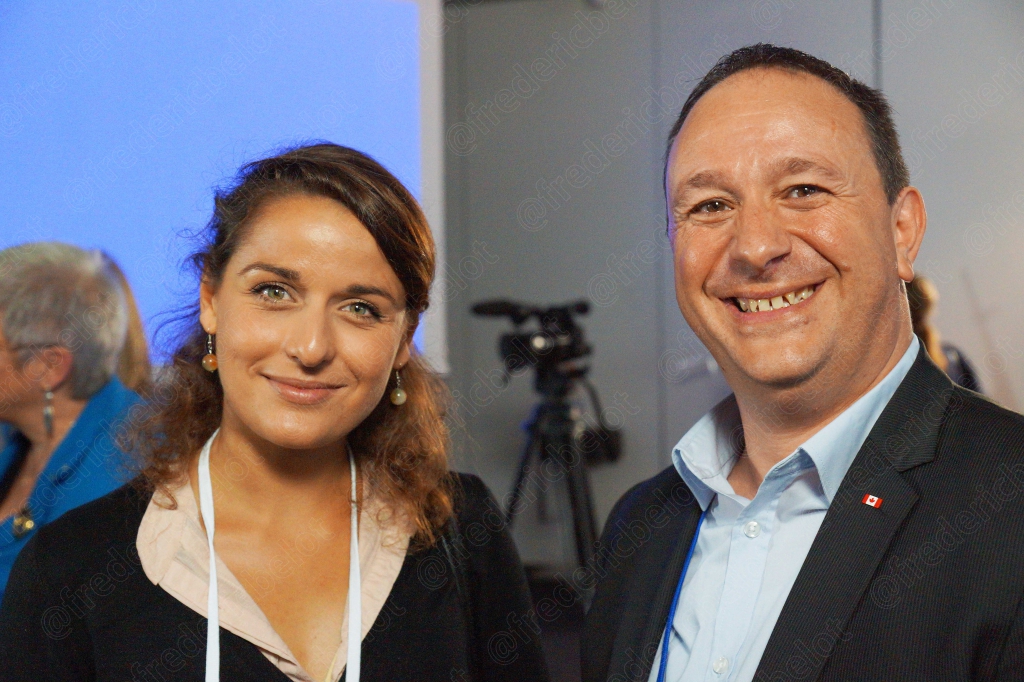 Un homme aux cheveux bouclés pose avec une femme aux cheveux longs, souriants.
