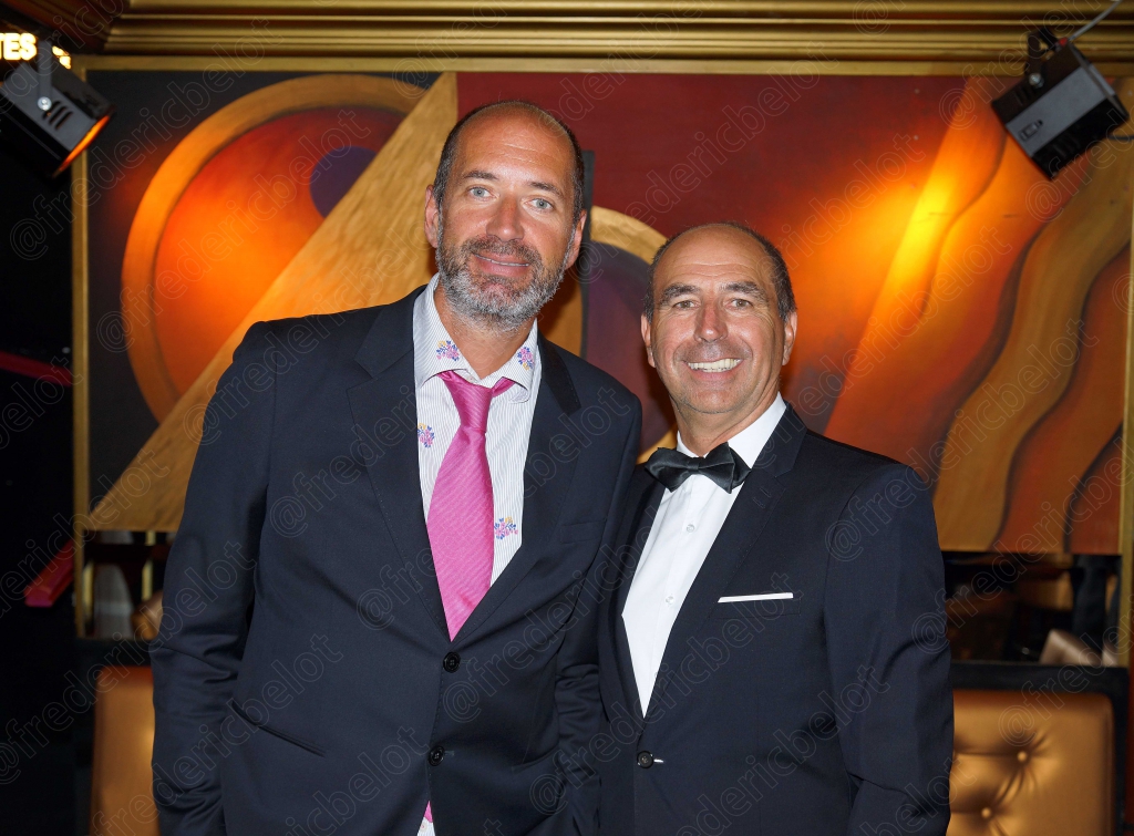Deux hommes en smoking posent ensemble devant le photo call.