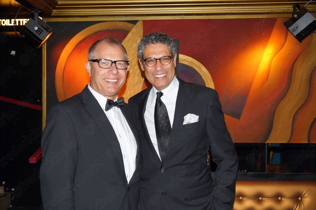 Deux hommes en smoking trinquent ensemble devant le photo call.