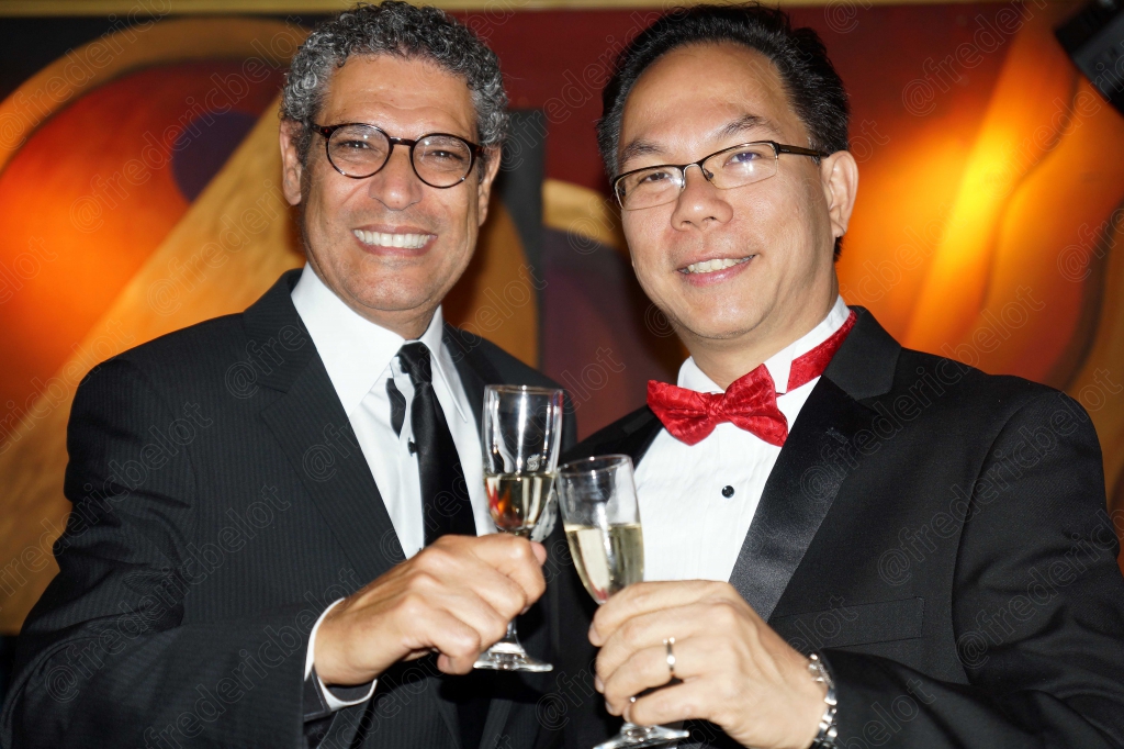 Deux hommes en smoking trinquent devant le photo call.
