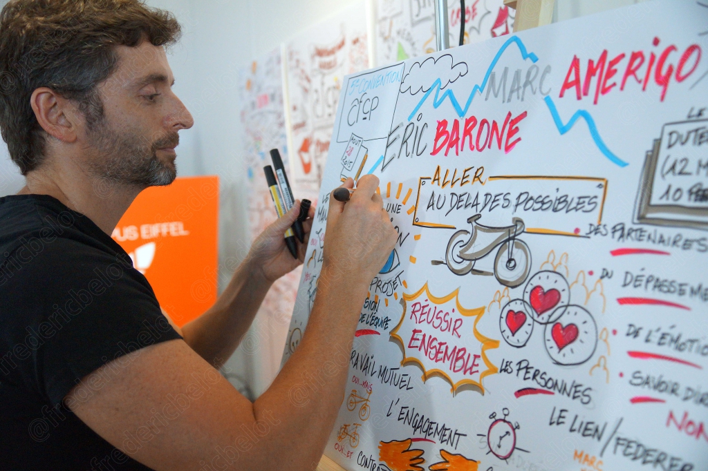 Le même intervenant sourit largement en s'adressant au public.