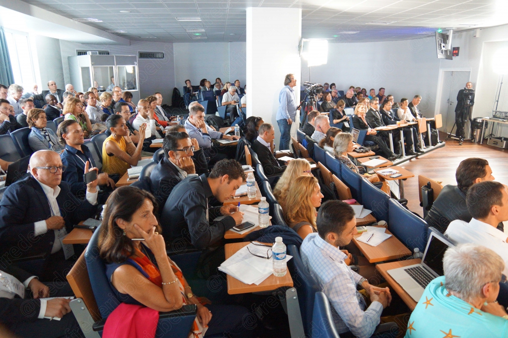 Quatre intervenants assis sur des tabourets hauts autour de tables rondes, en table ronde.