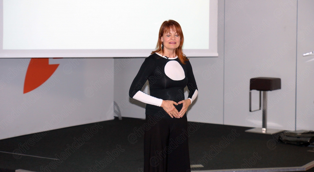 Le public assis suit attentivement la présentation, ordinateurs portables ouverts.