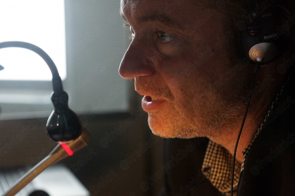 Gros plan sur un micro-casque et le profil d'un homme parlant