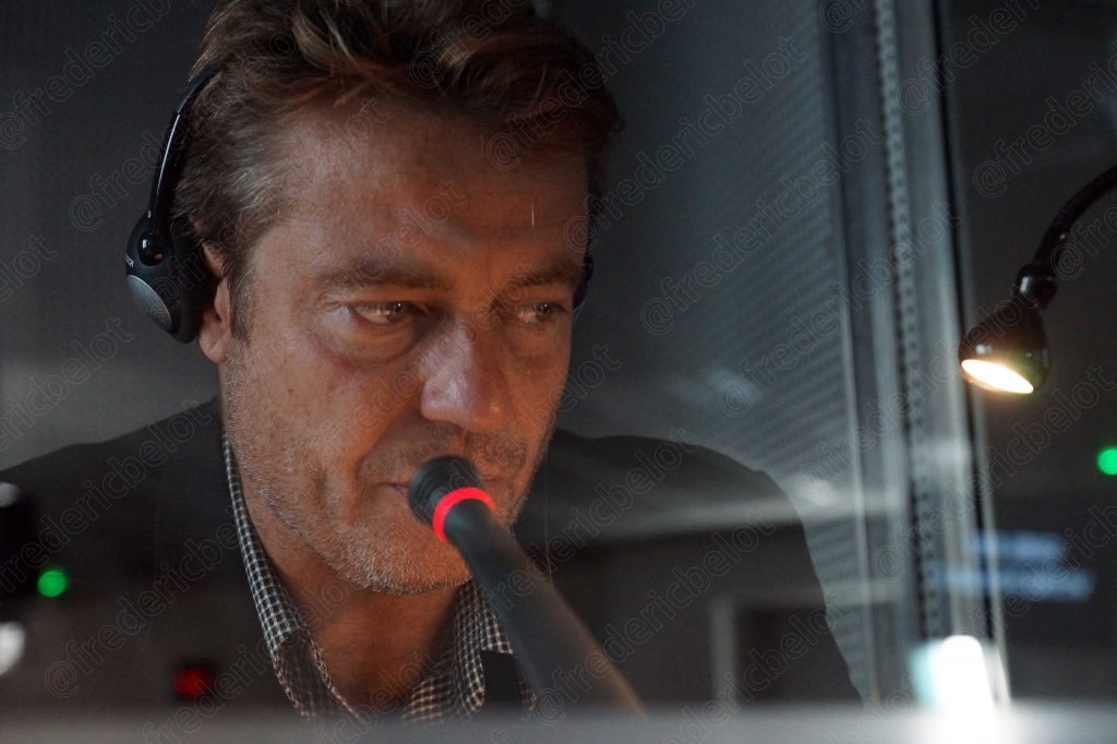 Homme portant un casque-micro de radio, cabine éclairée en rouge