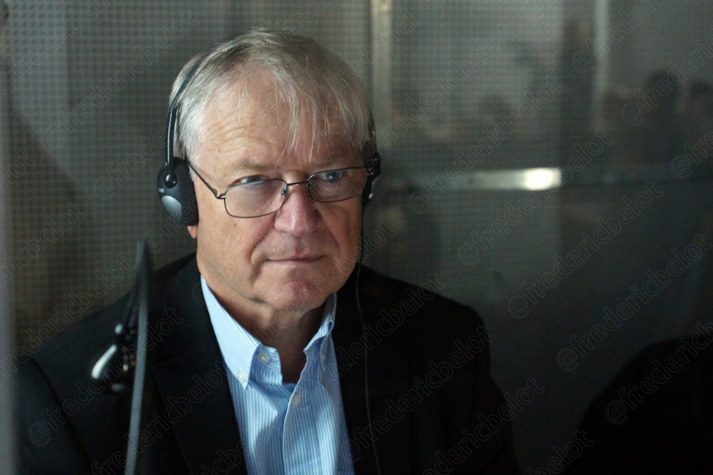 Homme aux cheveux gris portant un casque-micro de radio, lunettes