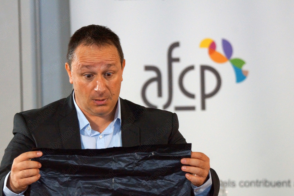Homme en costume dépliant un grand sac plastique noir devant lui