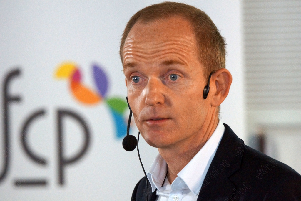 Homme portant un micro-casque, expression pensive, devant le logo afcp