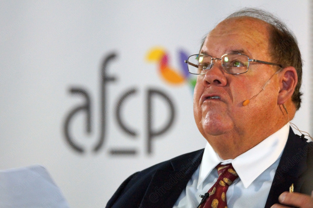 Homme en costume à lunettes, bouche ouverte, devant le logo afcp