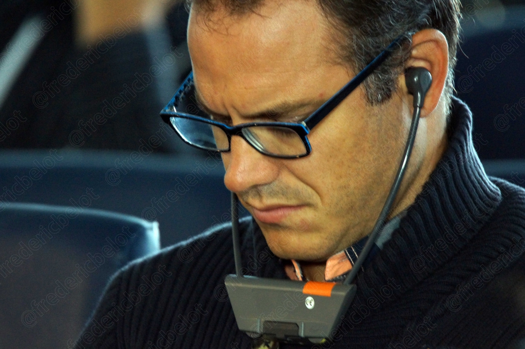 Homme à lunettes avec oreillette, dans le public