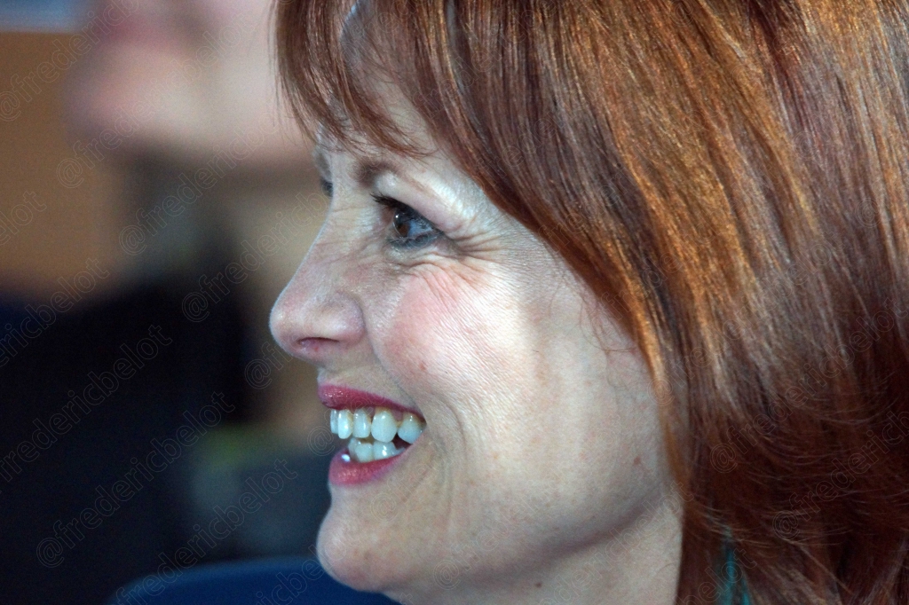 Femme aux cheveux roux riant, gros plan de profil