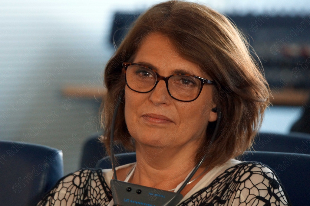 Femme à lunettes et cheveux roux, expression attentive