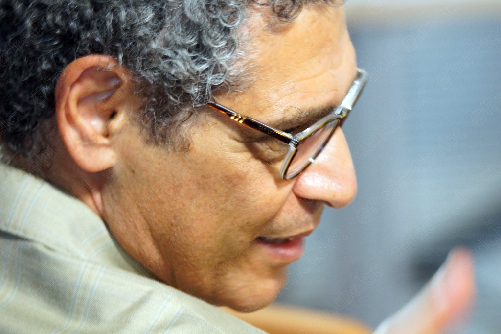 Homme aux cheveux bouclés grisonnants, lunettes, gros plan de profil