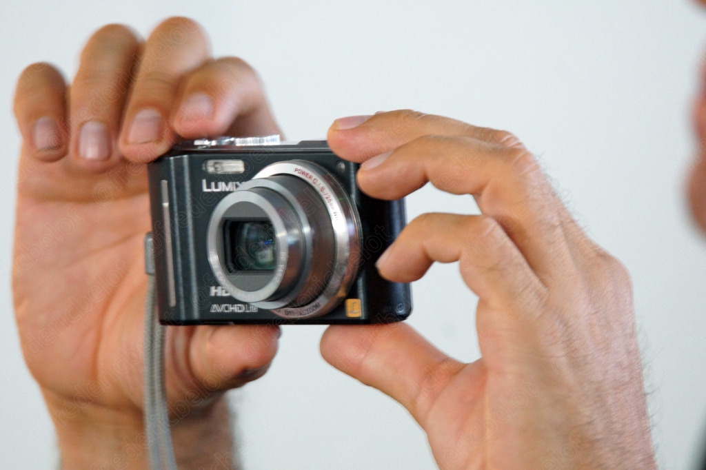 Gros plan sur une main tenant un appareil photo compact