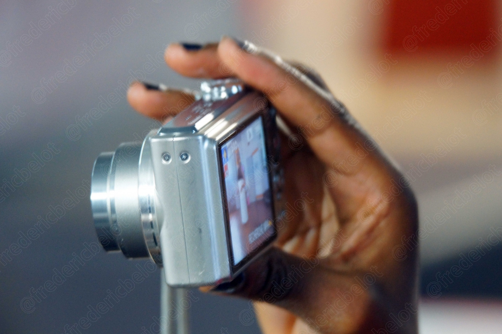 Gros plan sur une main tenant un appareil photo compact