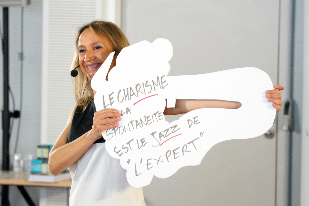 Femme micro-casque tenant une pancarte manuscrite sur le charisme et la spontanéité