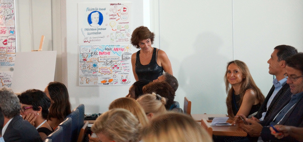 Femme debout devant un panneau de mind-mapping, public assis