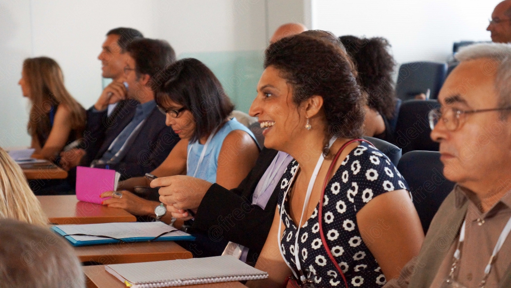 Groupe de participants souriants, dont une femme en tenue à motifs fleuris