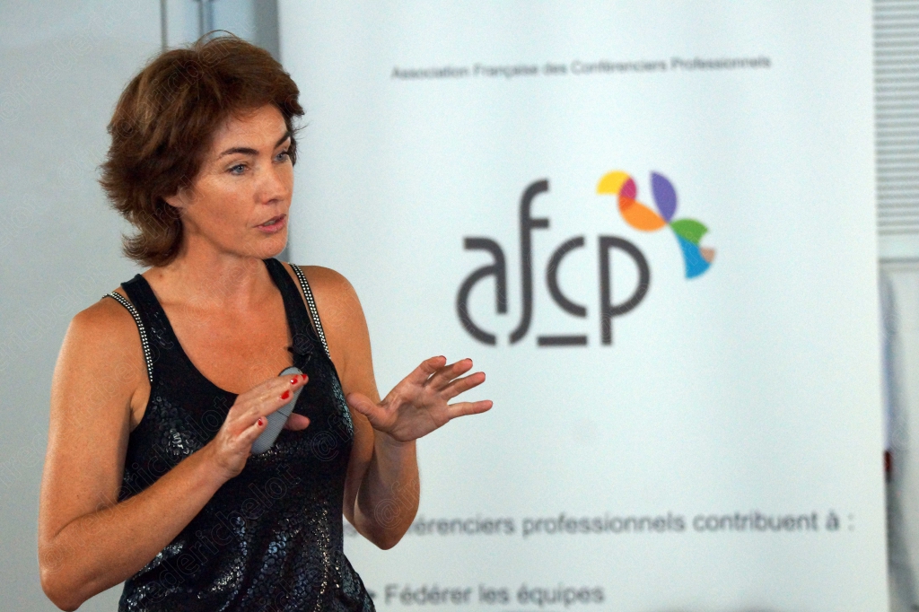 Femme en débardeur noir gesticulant, devant le logo afcp