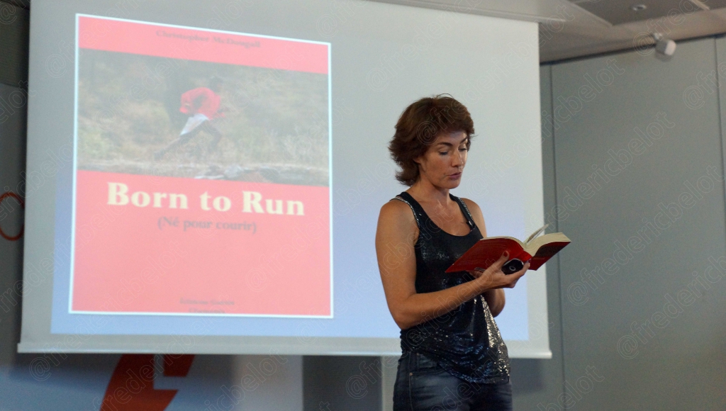 Femme en débardeur noir tenant un livre sur la course à pied