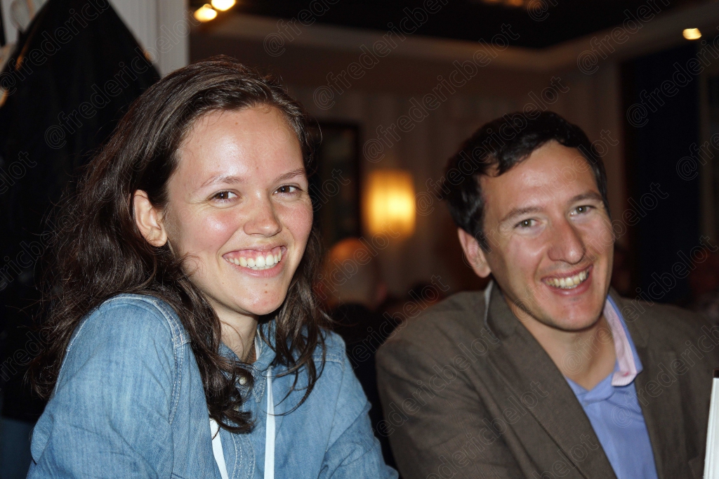 Une femme souriante et un homme posent ensemble pendant le repas.