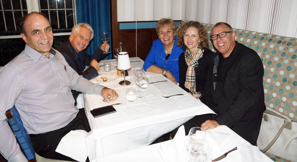 Un groupe de convives se réunit autour d'une table pour la photo.