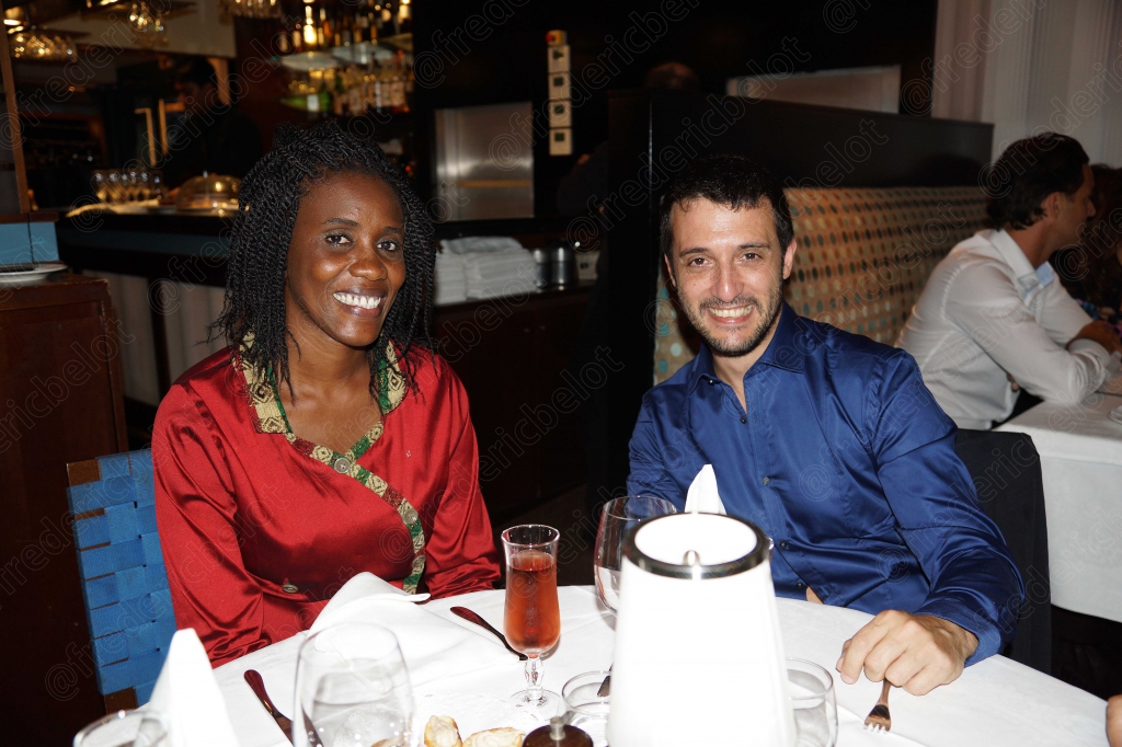 Une femme et un homme souriants posent côte à côte à table.