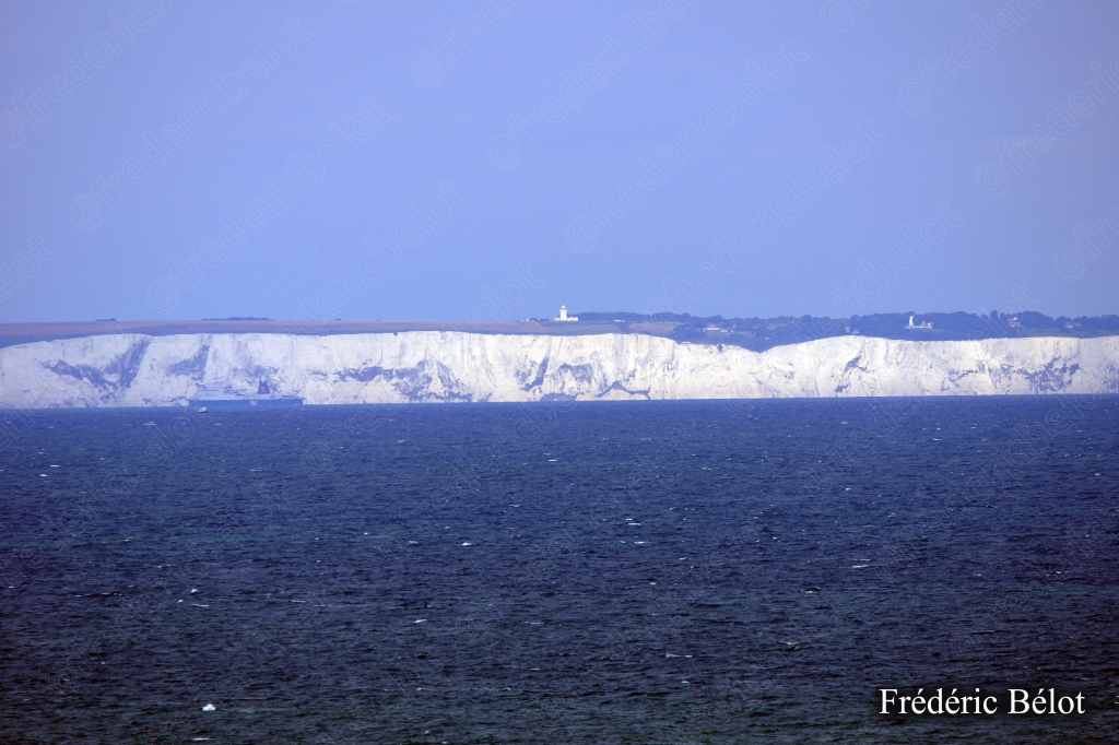 Les falaises blanches du Cap Blanc-Nez vues depuis la mer, ligne de craie sur l'horizon.