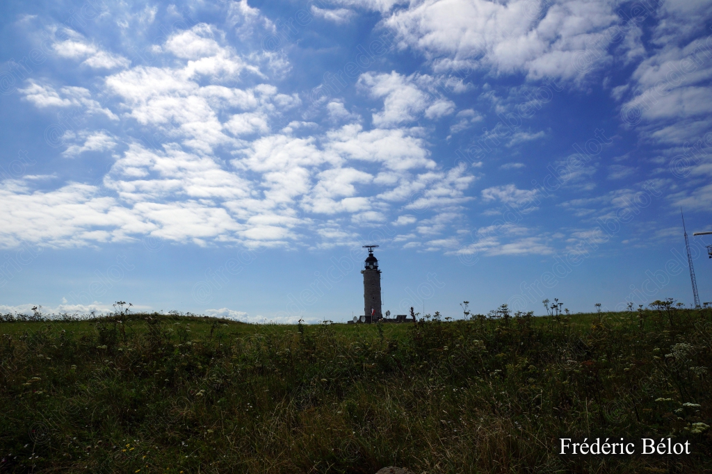Ciel nuageux au-dessus d'une prairie côtière, lumière changeante.