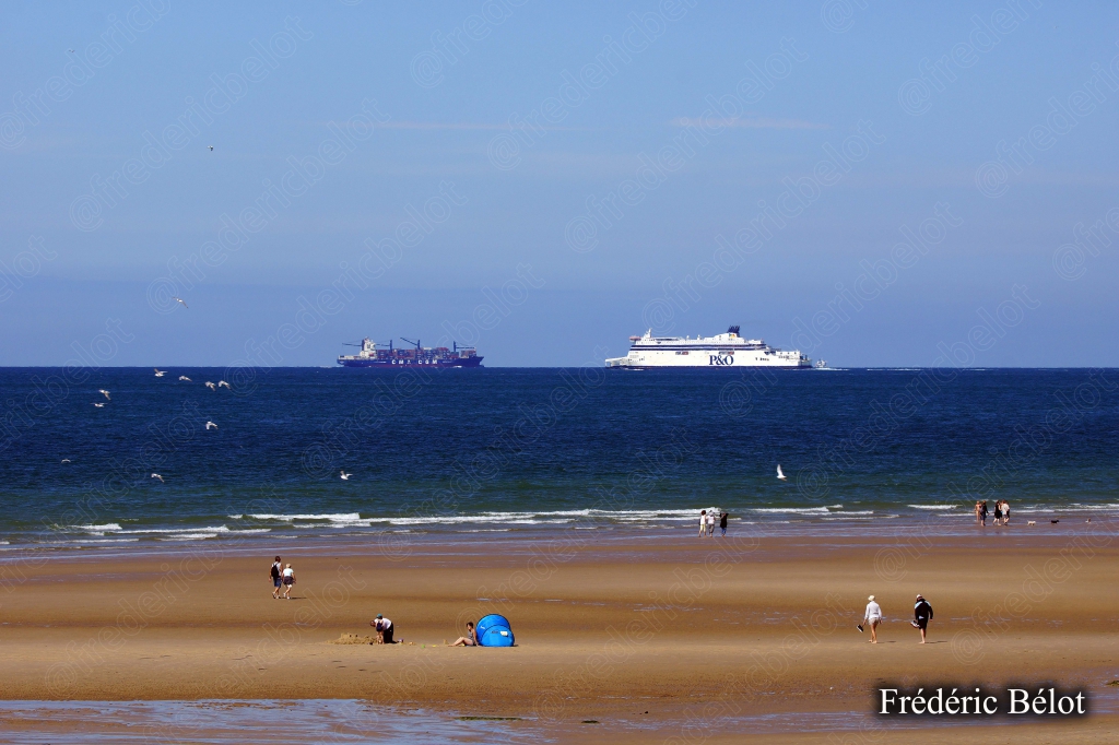 Les falaises blanches de craie s'étendent le long de la côte, un bateau au large.