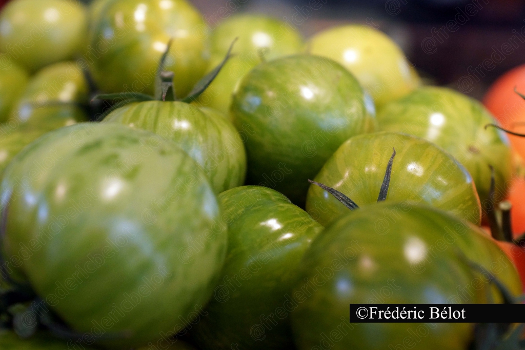 Des tomates vertes zébrées présentées en gros plan.