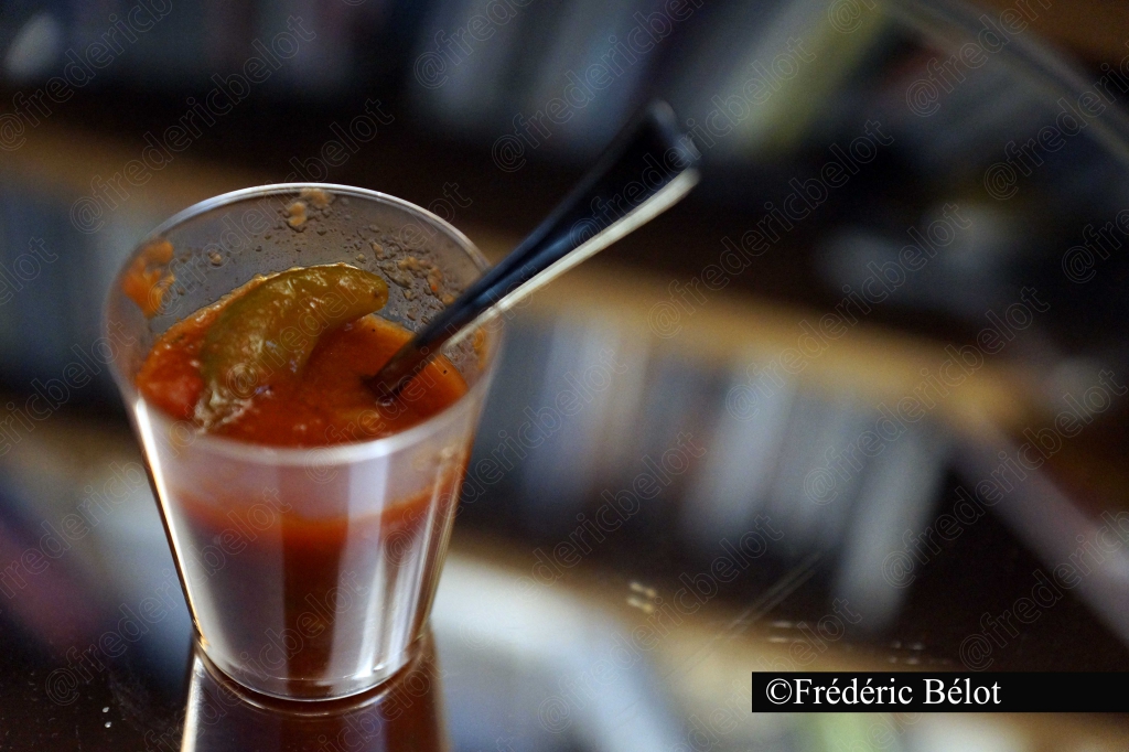 Un verre de gaspacho ou de soupe froide avec une paille.